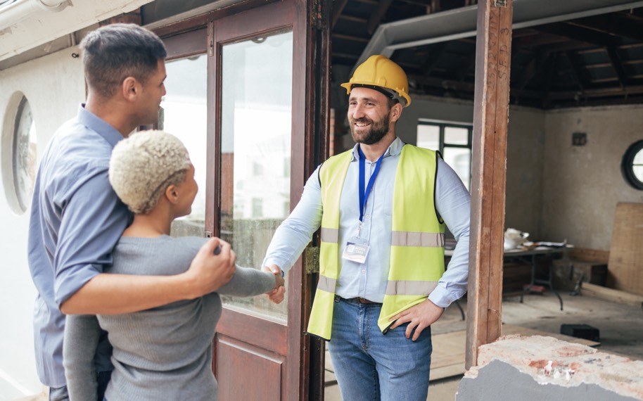 A contractor shaking hands with homeowners